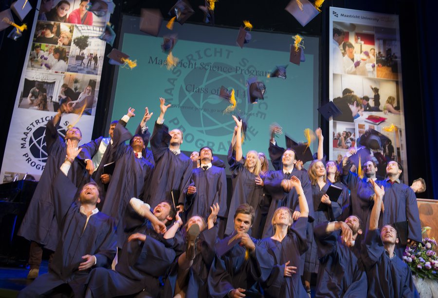 The class of 2014 throwing their caps on the theatre stage
